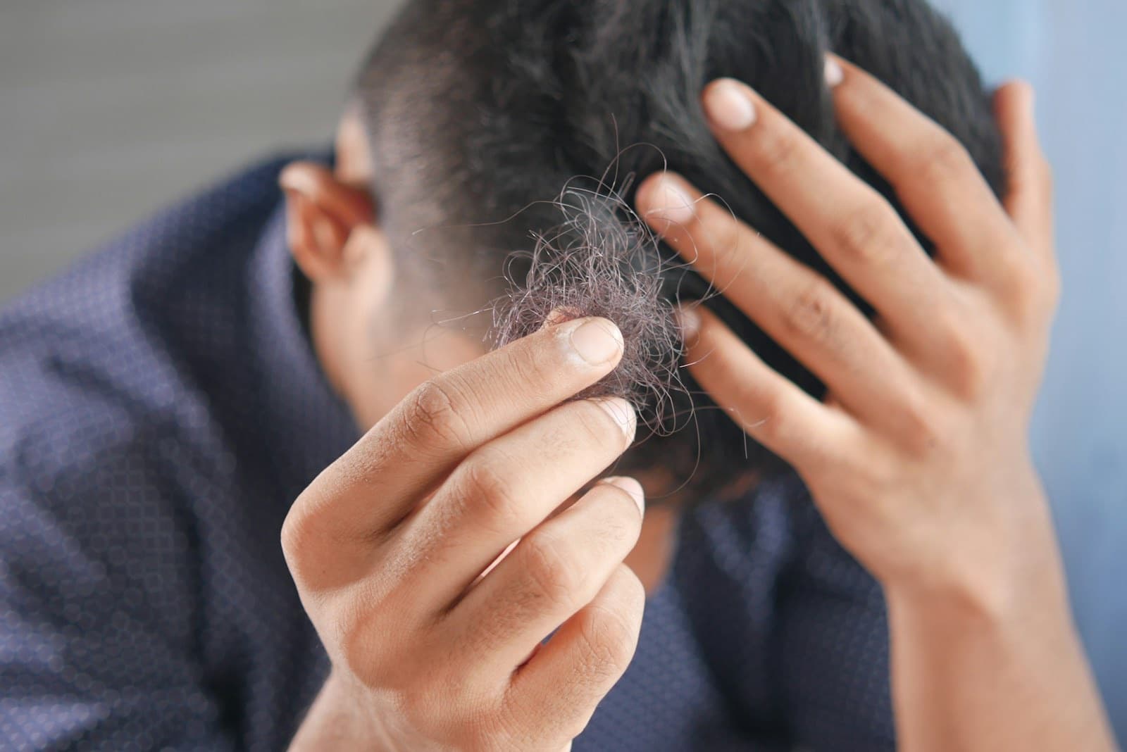 Man running hands through his hair, representing hair loss treatment at LovMedSpa